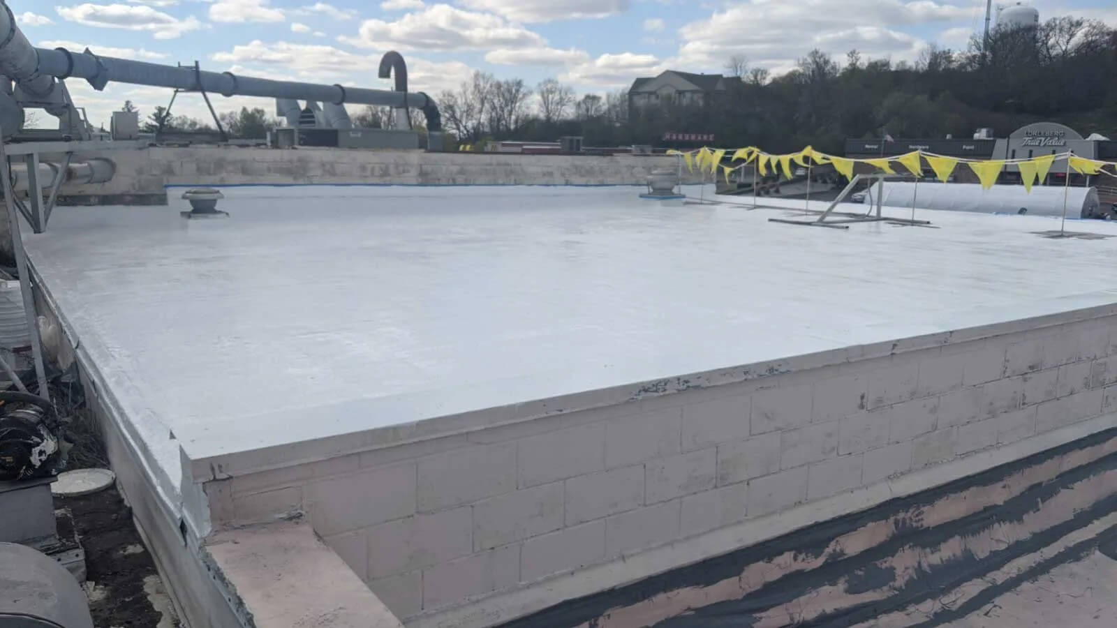 Completed white roof restoration on a multi-level commercial building in Milwaukee